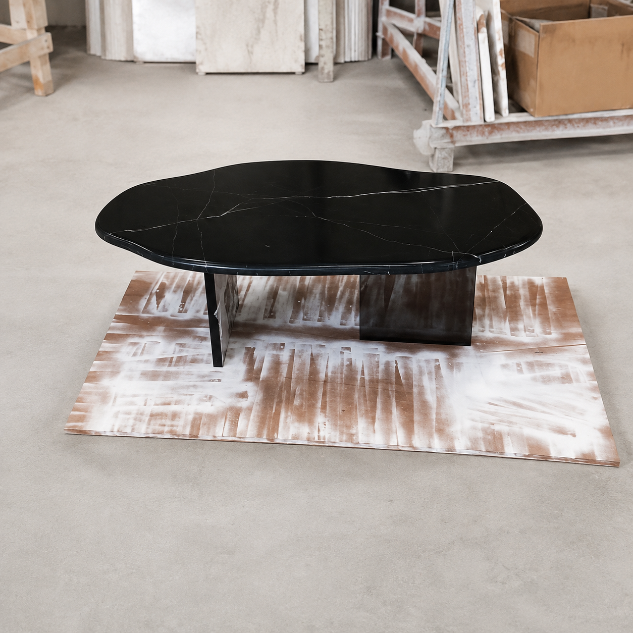 Actual finished AquaFlow Black Marquina marble coffee table with clear acrylic bases, front workshop view