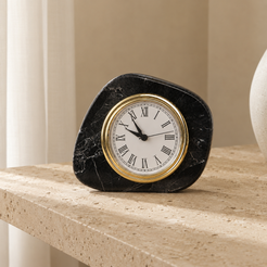 Black marble desk clock styled on a beige travertine stone table
