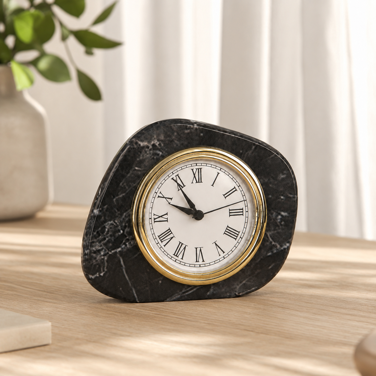 Black marble tabletop clock in side angle view with white veining and gold clock frame