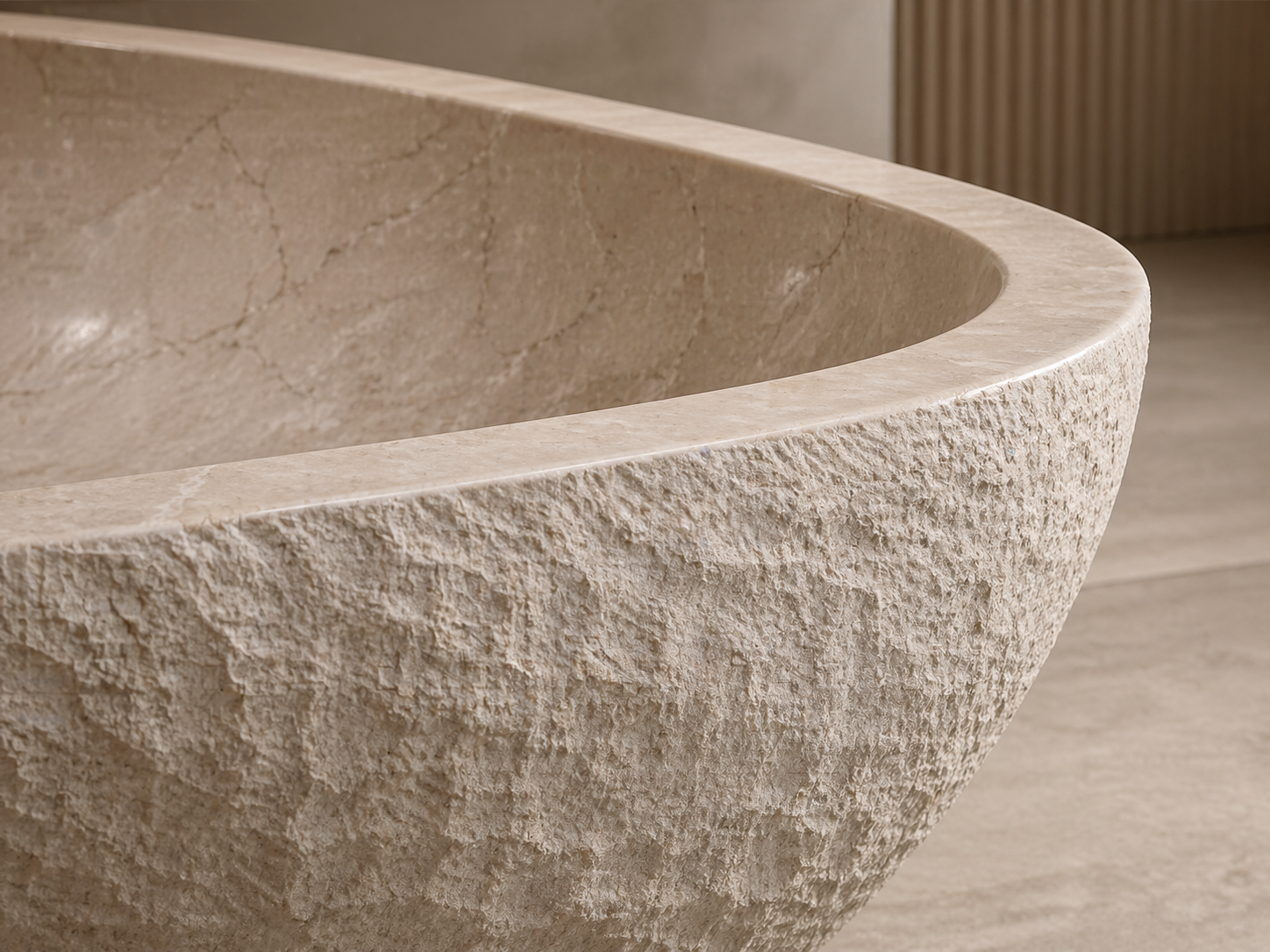 Close-up of a natural stone tub with smooth honed interior and textured hand-finished exterior