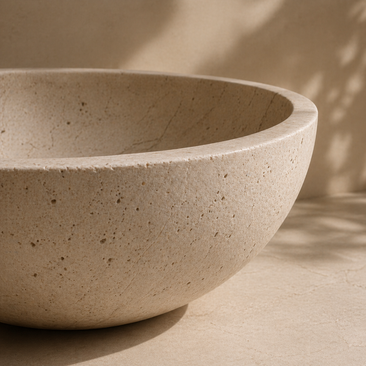 Close-up of a natural stone basin with smooth curved form and porous surface detail