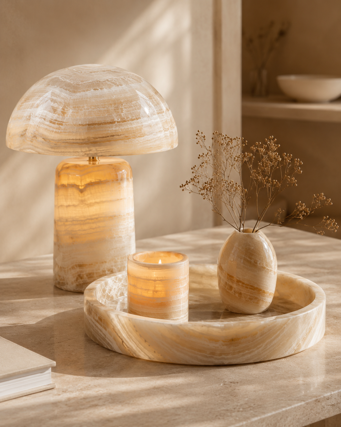 Glowing onyx lamp, candle holder, tray, and vase arranged in a warm interior setting, illustrating gentle onyx care.
