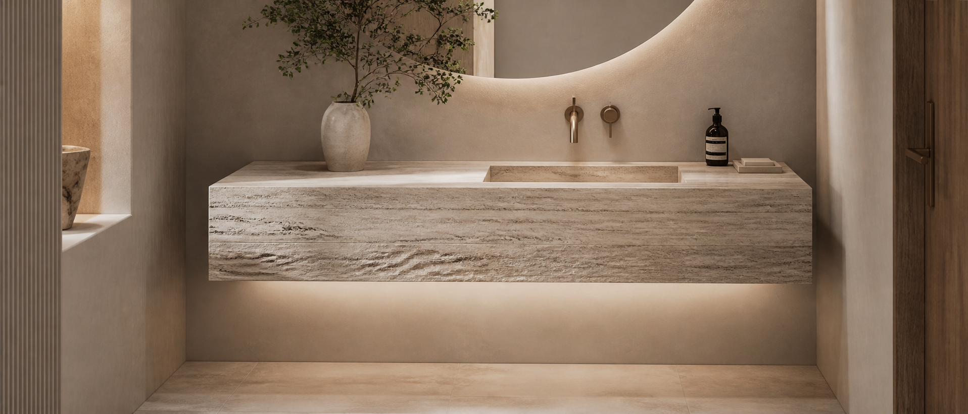 Minimalist bathroom with a floating natural stone wall-mounted sink and brass wall faucet