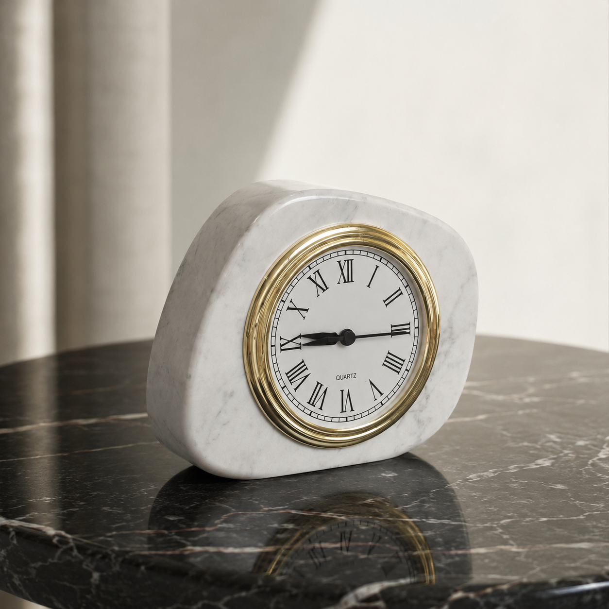 White marble tabletop clock with gold frame styled on a dark stone table