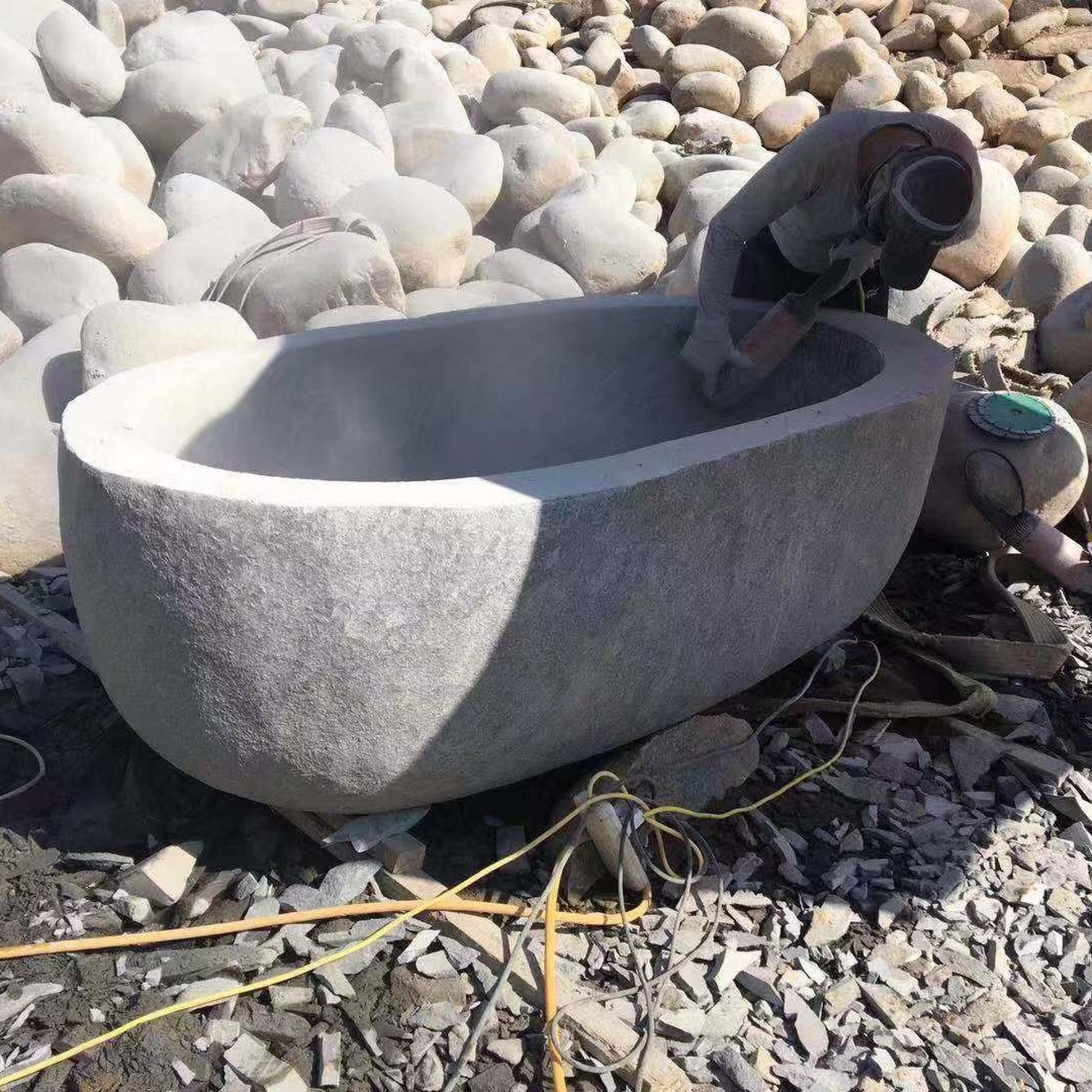 OIXDESIGN granite bathtub hand-finishing process showing skilled manual surface refinement