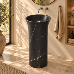 Pamala Portoro marble pedestal sink in a warm ivory and oak bathroom with natural daylight
