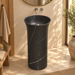 Pamala Portoro marble pedestal sink in a warm bathroom with oak joinery and side window