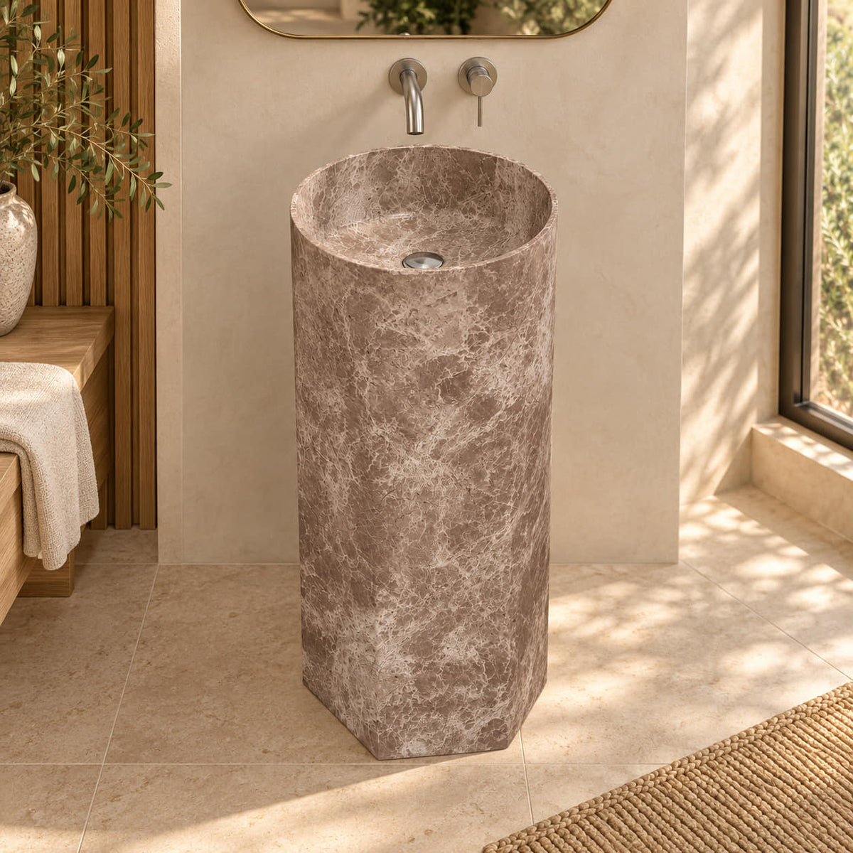 Patali Dorata marble pedestal sink with circular basin and faceted base in a warm oak and ivory bathroom