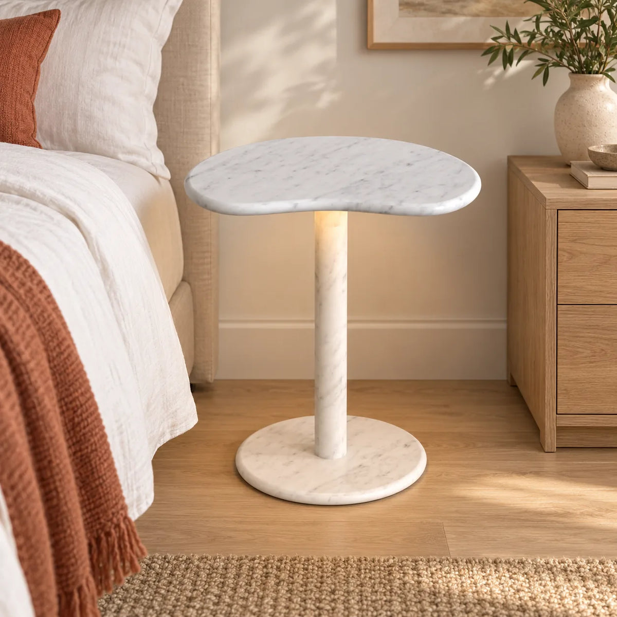 PeaPod Carrara marble smart-edition side table beside a linen bed, shown from a mid-height front view