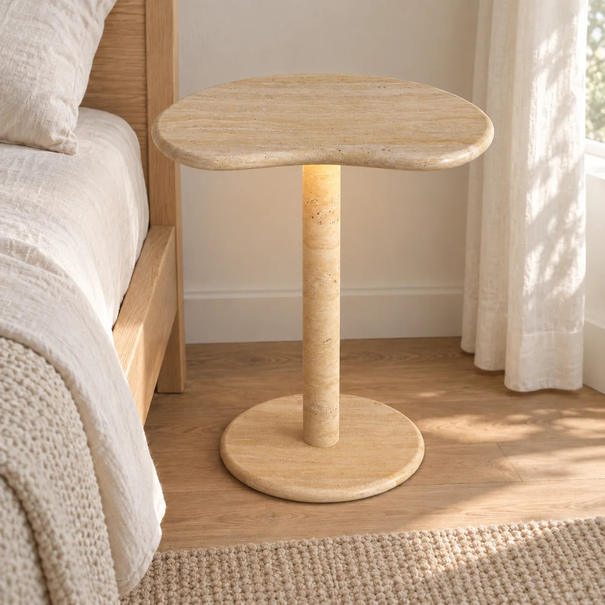 PeaPod Italian Classico travertine smart-edition side table beside a linen bed, shown from a moderate front view