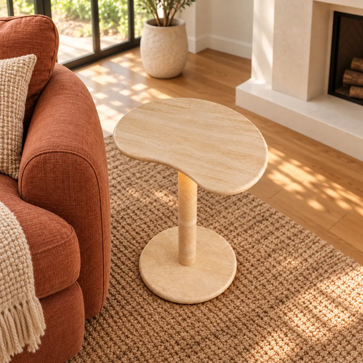 PeaPod Italian Classico travertine smart-edition side table beside a rust linen sofa, shown from a high front-quarter view