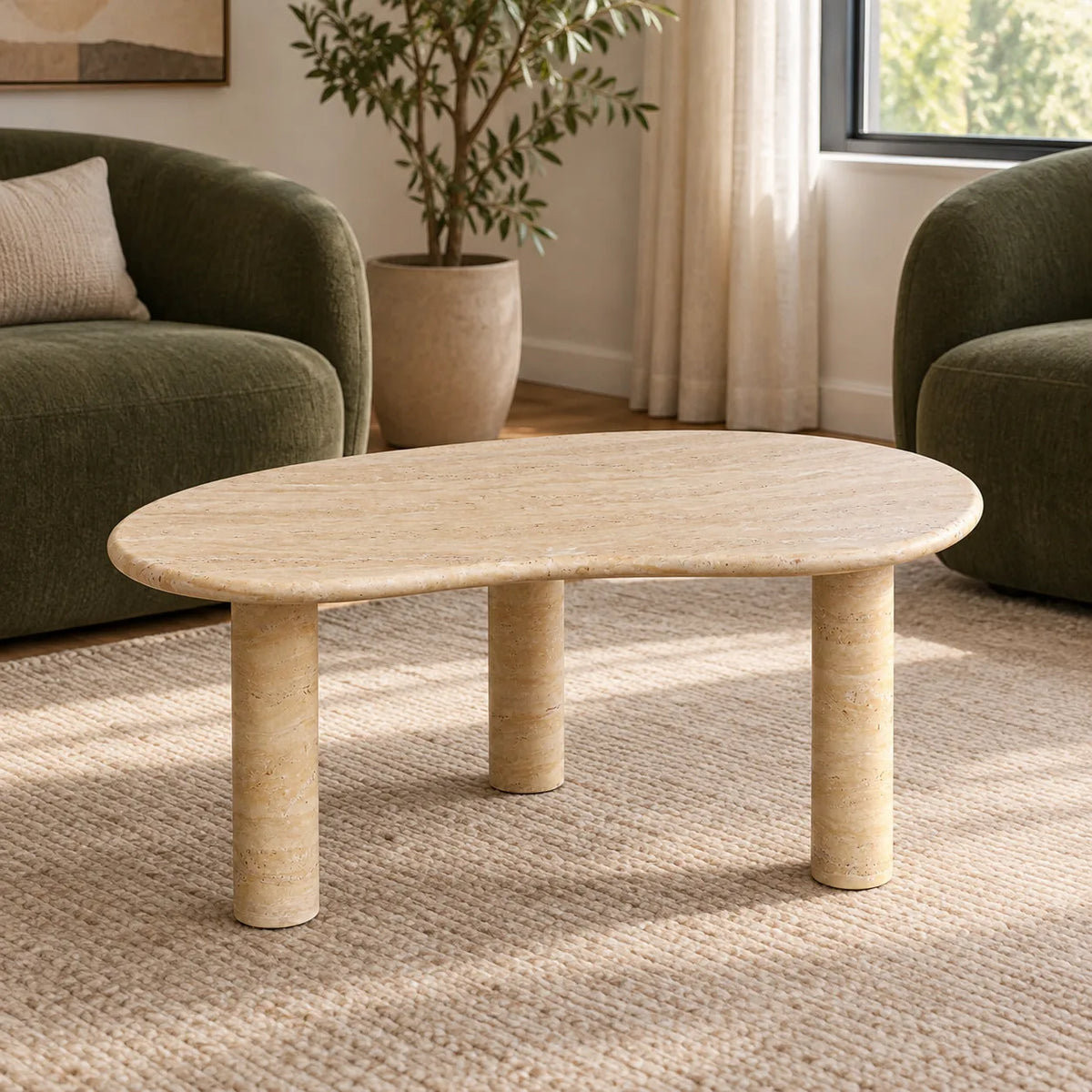 PeaPod Italian Classico travertine coffee table with a thin curved top and three cylindrical stone legs in a warm window-side reading nook.
