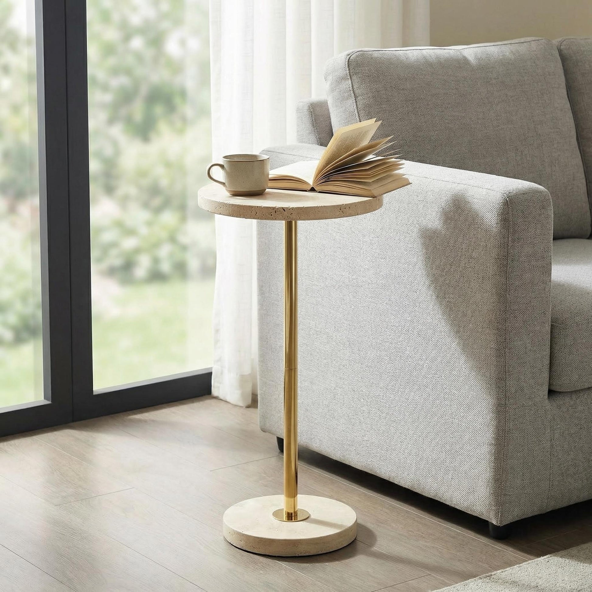 Pillar travertine side table used beside a sofa in a modern living room
