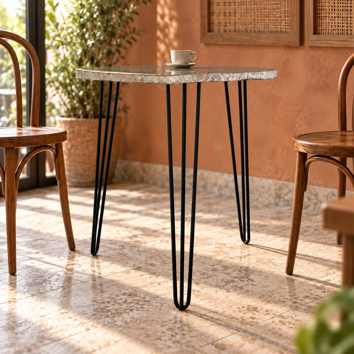 RiverStone natural river stone dining table with black iron hairpin legs in a warm cafe corner
