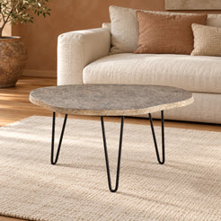 RiverStone Yellow River Stone coffee table with three black hairpin legs in a warm linen-sofa living room, viewed from the front