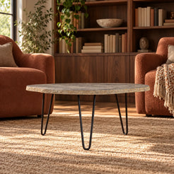 Low front view of the RiverStone Yellow River Stone coffee table in a terracotta-chair reading nook, with its thin natural edge and black hairpin supports visible