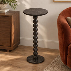 RoundBall Dark Emperador marble cocktail table beside a walnut cabinet and velvet chair, shown from a moderately elevated view