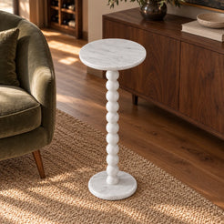 RoundBall Carrara marble cocktail table beside a walnut sideboard and sage chair, shown from a moderately elevated view