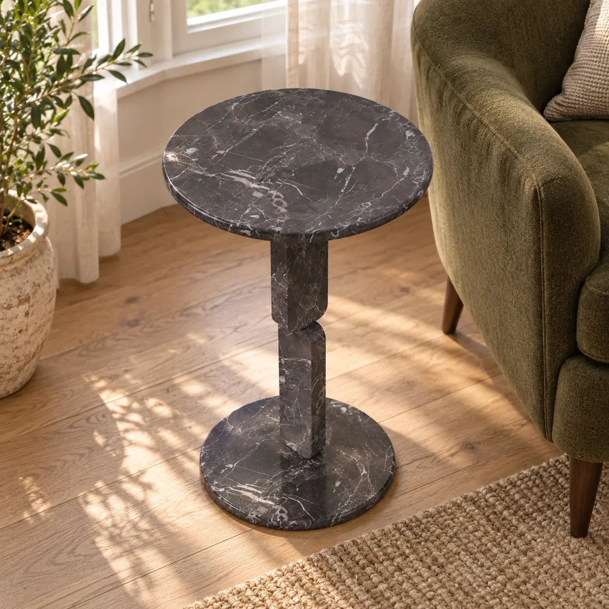 RoundGeo Dark Emperador marble side table in a bay-window reading nook, shown from a high downward view