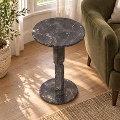 RoundGeo Dark Emperador marble side table in a bay-window reading nook, shown from a high downward view