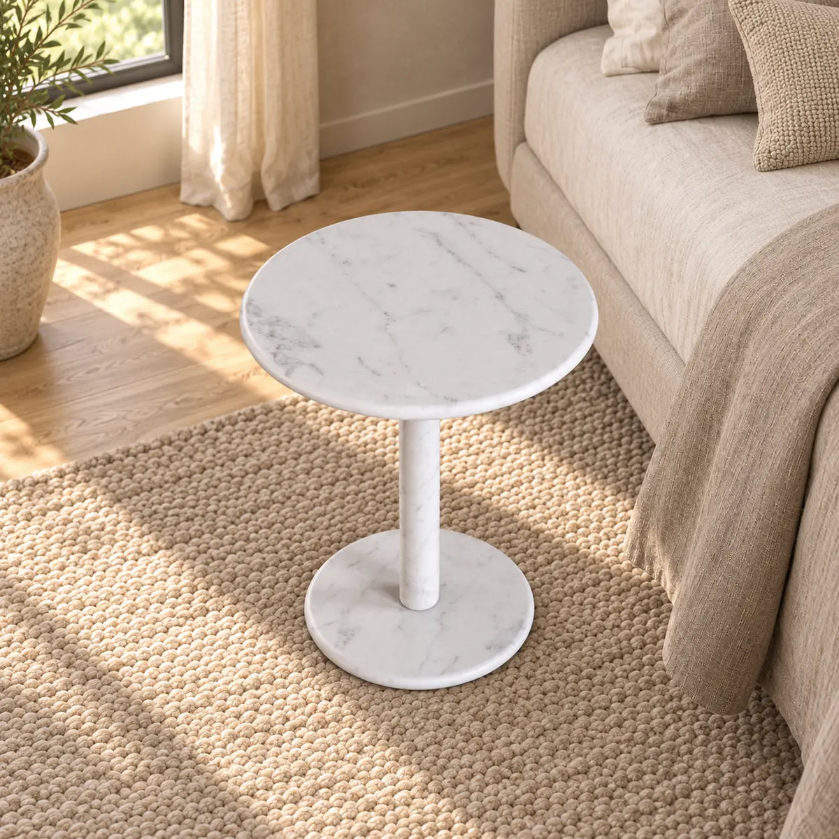 RoundHaven Carrara marble Standard side table in a linen bedroom, shown from an elevated front-quarter view