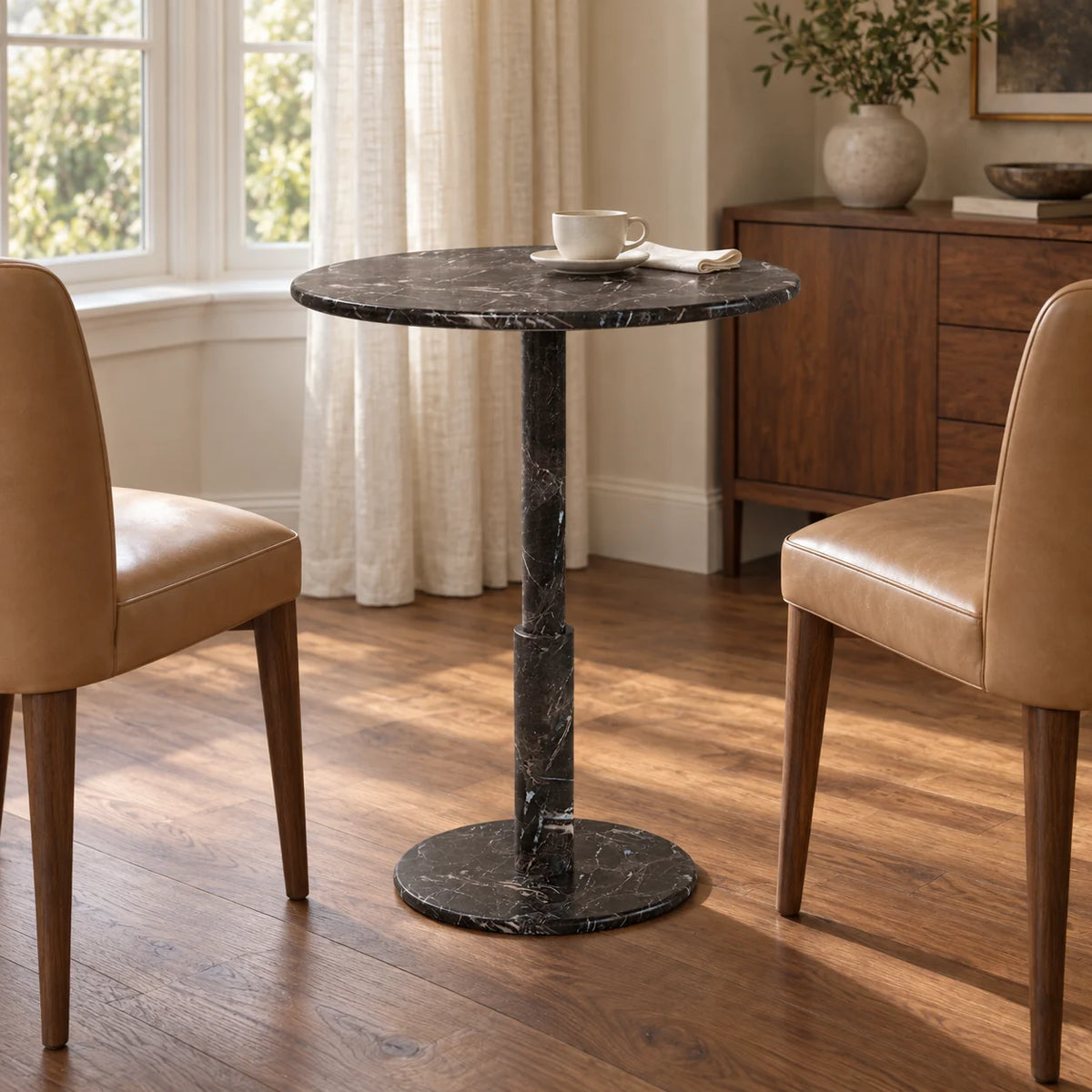RoundTwin Small Black marble dining table in a warm home dining alcove, low front view