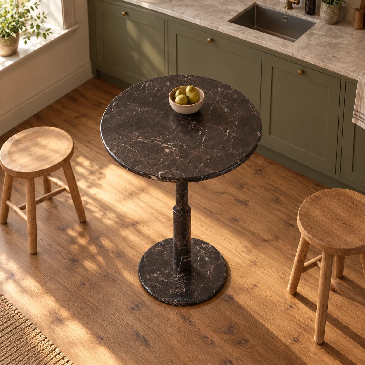 RoundTwin Small Black marble dining table in a warm kitchen breakfast corner, high oblique view