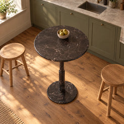 RoundTwin Small Black marble dining table in a warm kitchen breakfast corner, high oblique view
