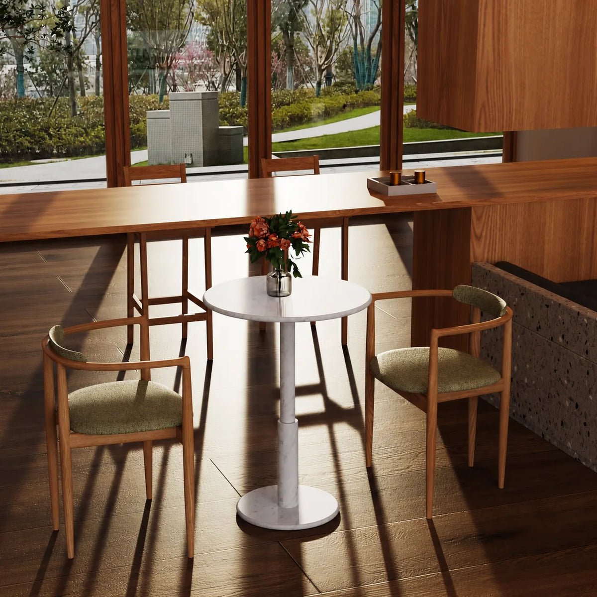 RoundTwin Small Carrara white marble dining table in a sunlit cafe, viewed from an elevated angle