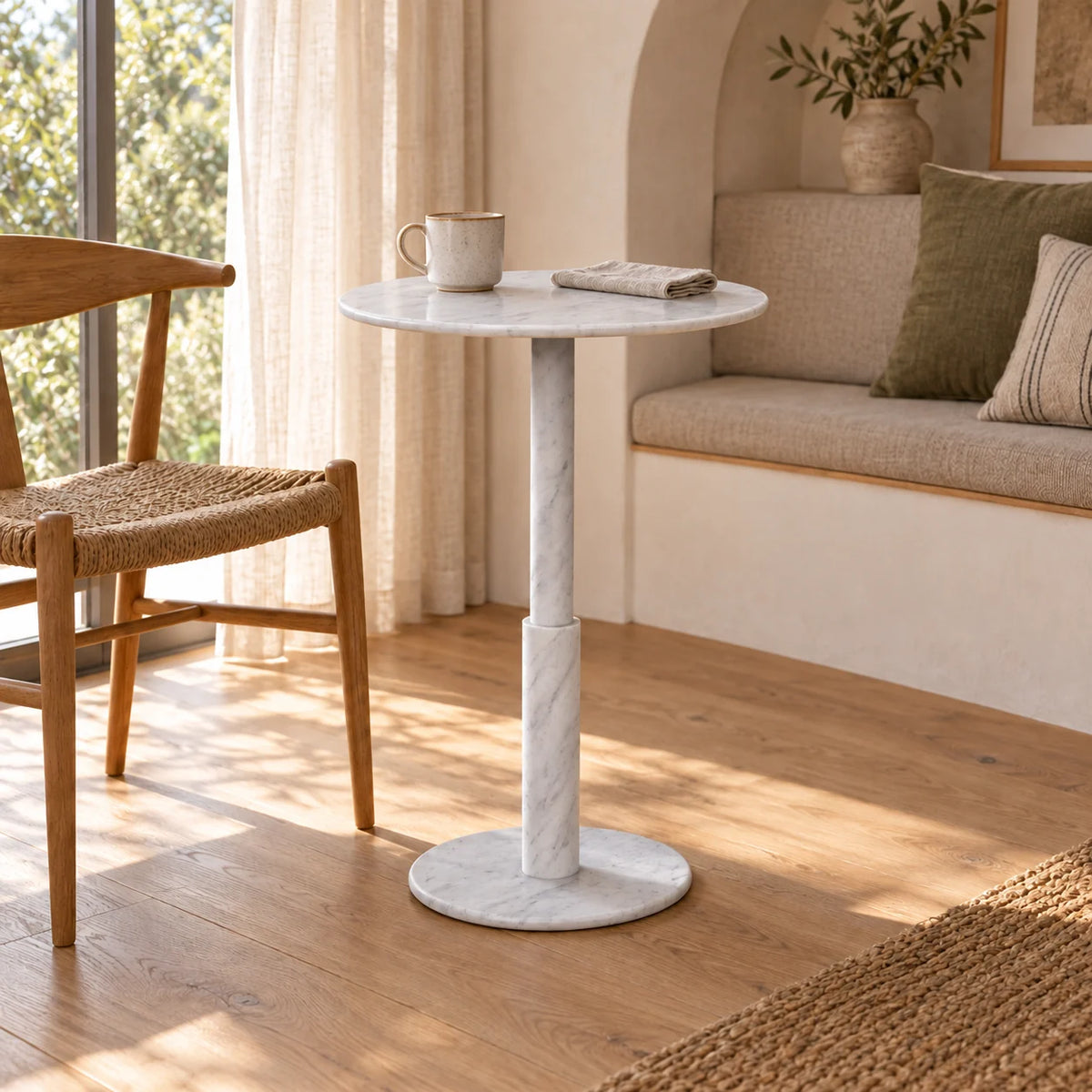 RoundTwin Small Carrara white marble dining table in a home breakfast corner, viewed from a low angle