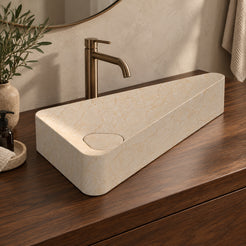 Illustrative reverse-angle walnut vanity setting of the Sabala triangular Crema marble basin