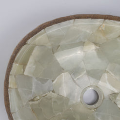 Saccus close-up of irregular pale mosaic pieces, joints and drain opening