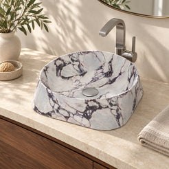 Illustrative three-quarter bathroom lifestyle of the Safira Calacatta marble vessel sink with a rounded triangular form