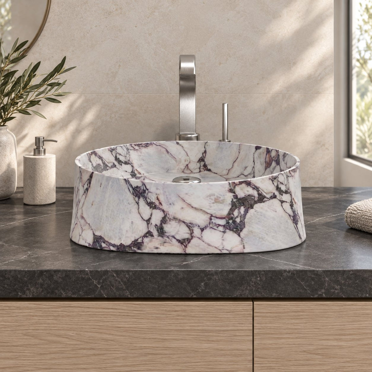 Illustrative low frontal bathroom lifestyle of the Safira Calacatta marble vessel sink with a rounded triangular form