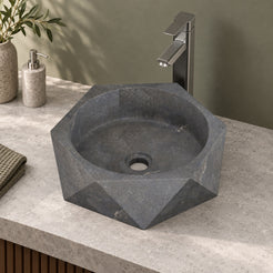 Secca bluestone vessel sink, faceted exterior and round basin, on a countertop from a second angle