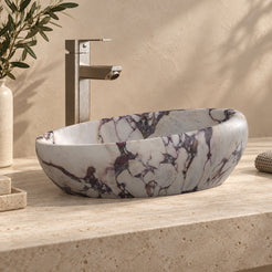 Selema Calacatta marble vessel sink, asymmetric oval bowl, on a countertop from a second angle