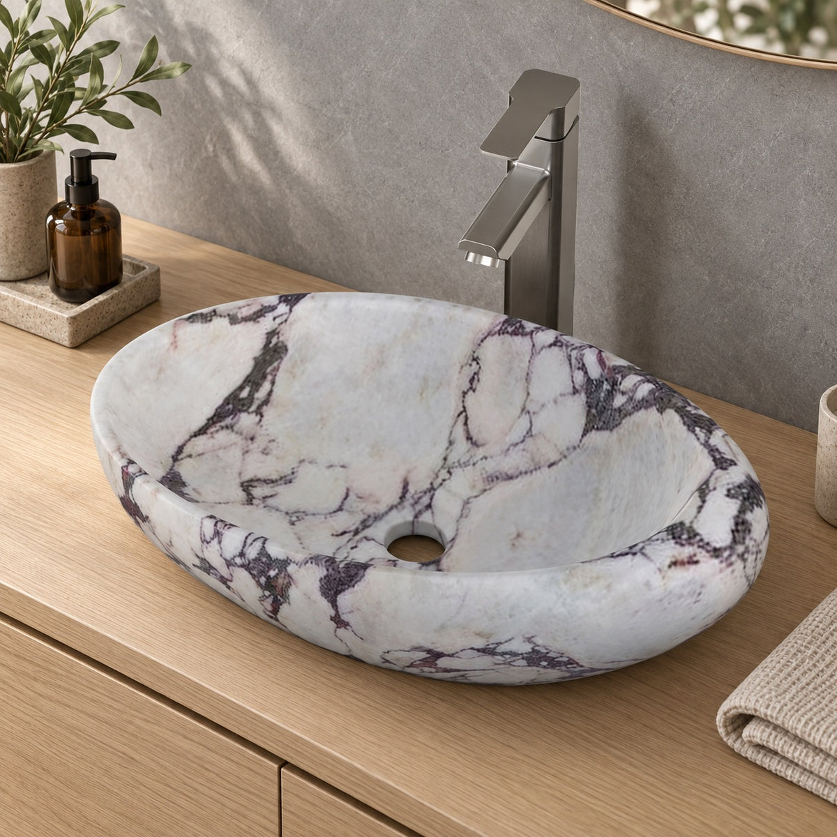 Selema Calacatta marble vessel sink, asymmetric oval bowl, in an overhead or alternate countertop setting