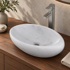 Selema Carrara marble vessel sink, asymmetric oval bowl, in an overhead or alternate countertop setting