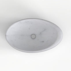 Selema Carrara marble vessel sink, asymmetric oval bowl, showing the basin interior, material and drain area