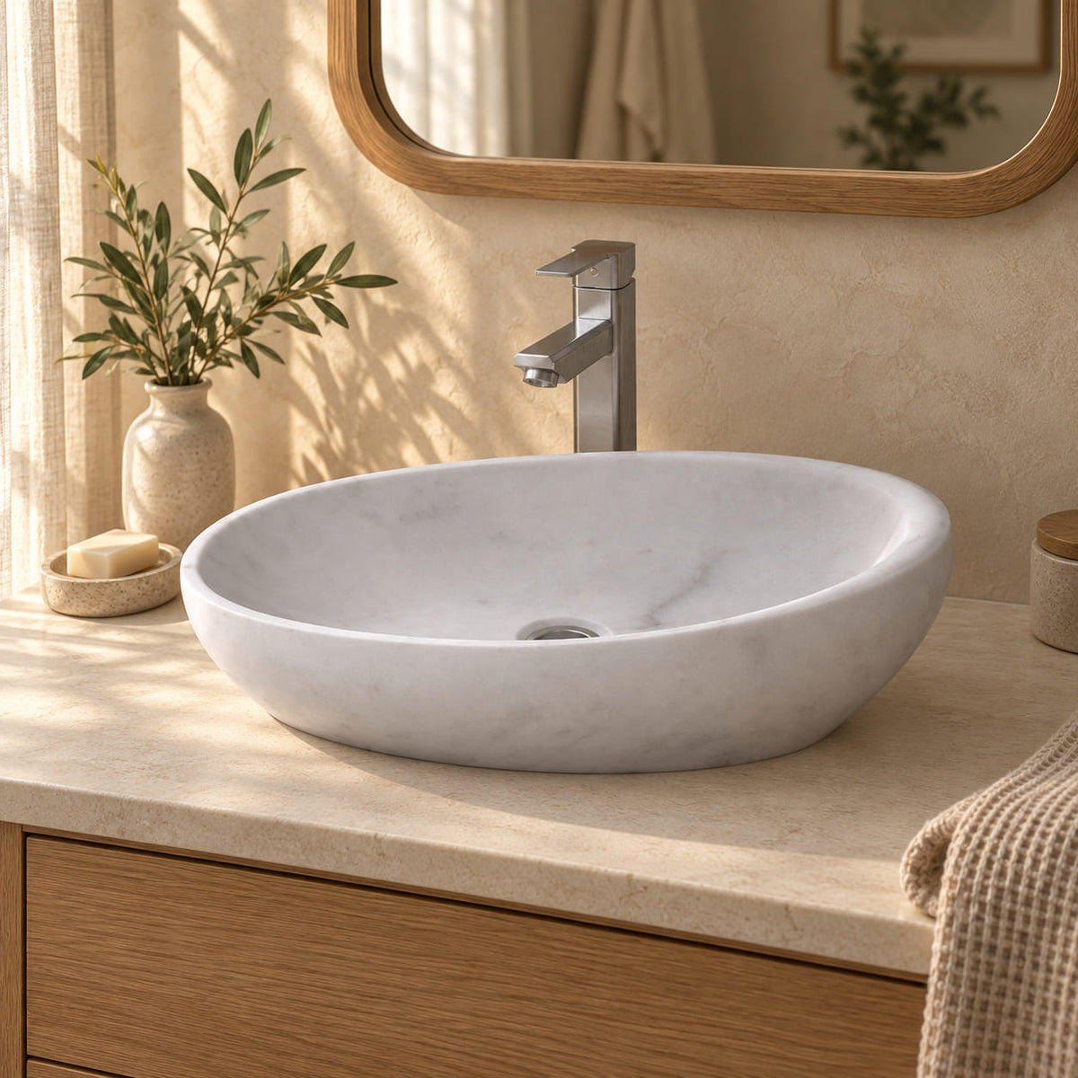 Selema Carrara marble vessel sink from the front in a warm ivory bathroom