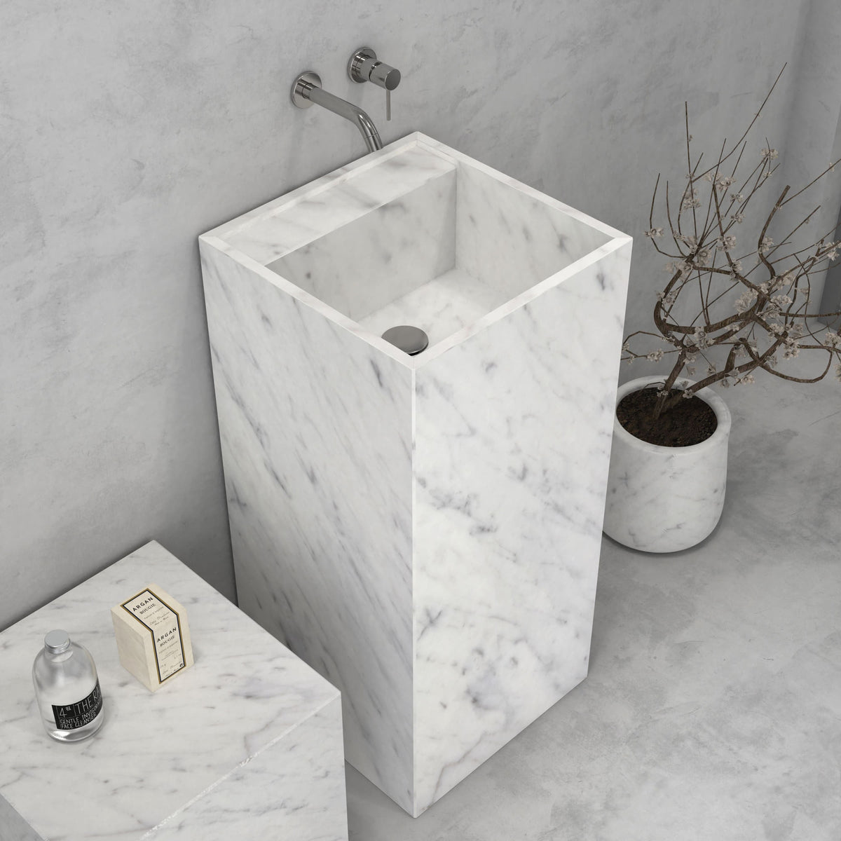 Angled bathroom view of the Panini Carrara marble pedestal sink with its rectangular column