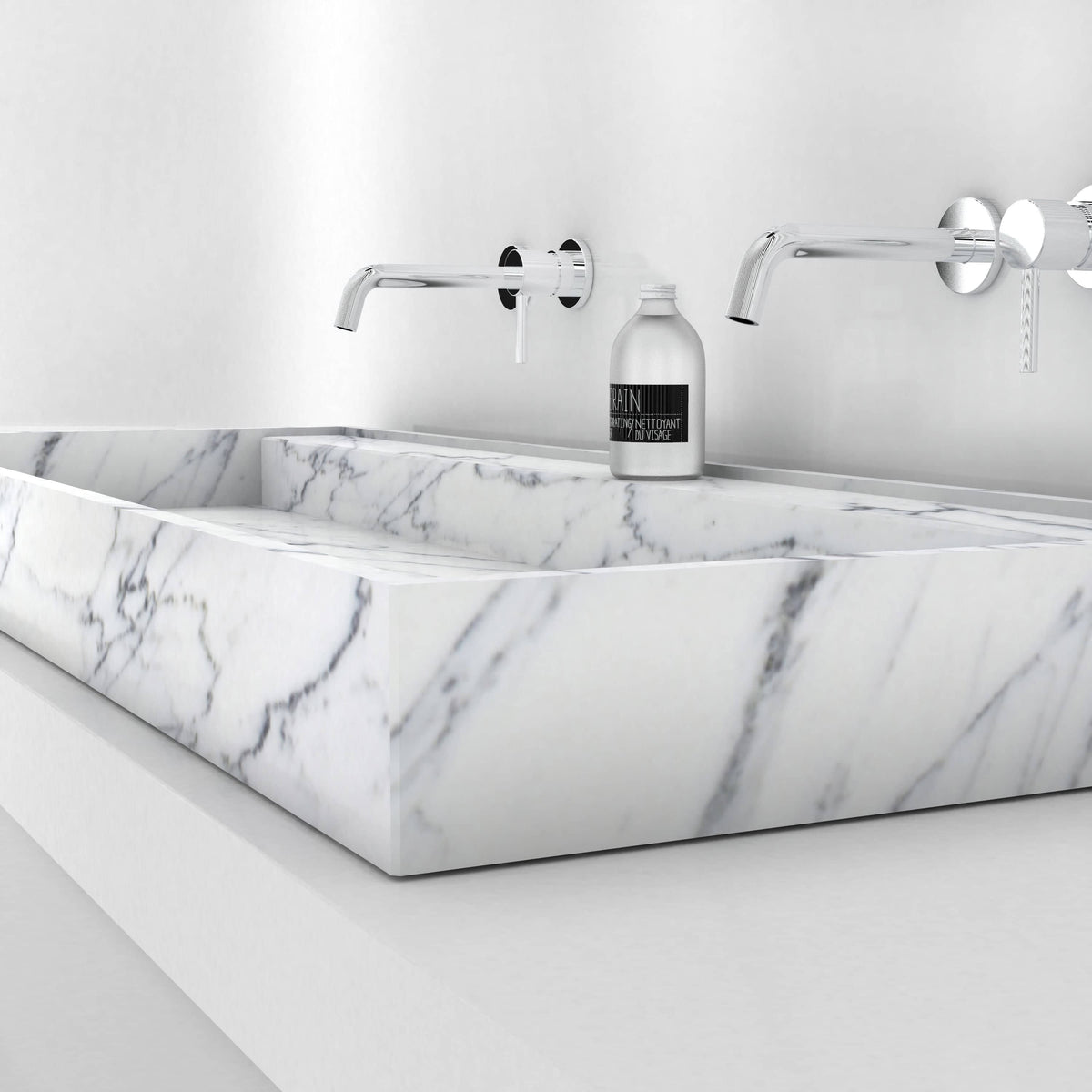 Low side view of the Tahira Carrara marble trough sink showing its veined front rim