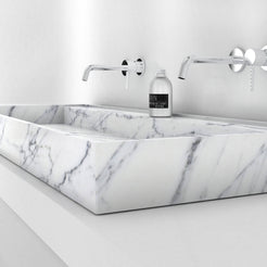 Low side view of the Tahira Carrara marble trough sink showing its veined front rim
