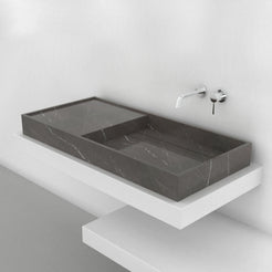 Angled view of the Tavira Perlato marble basin with an extended surface beside the sink