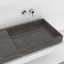Close view of the Tavira Perlato marble basin showing its sloped interior and subtle veining