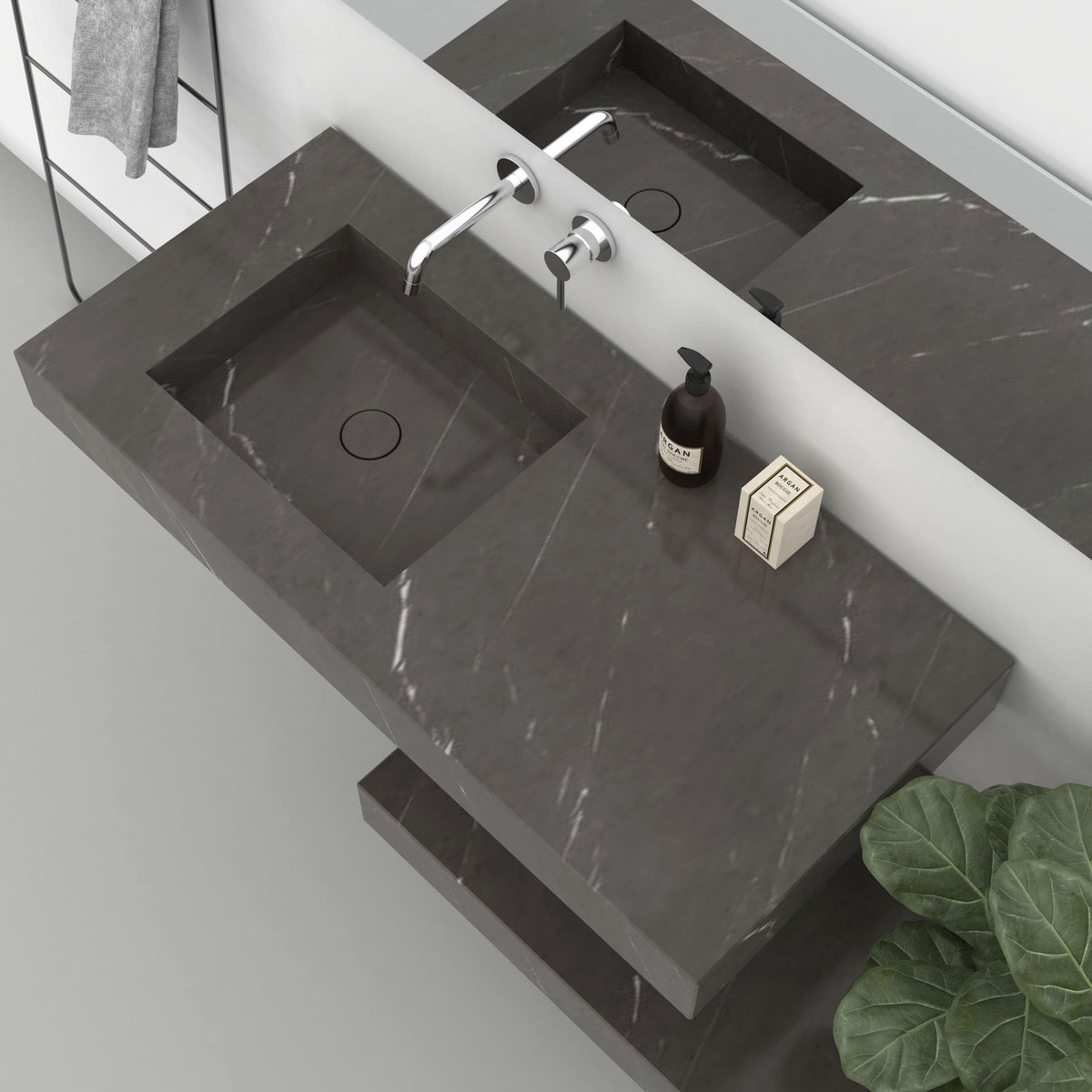 Overhead view of the Tacita Perlato marble basin showing its drain and adjacent stone surface
