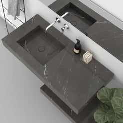 Overhead view of the Tacita Perlato marble basin showing its drain and adjacent stone surface