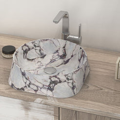 Safira soft triangular Calacatta marble basin on a wood vanity, oblique view