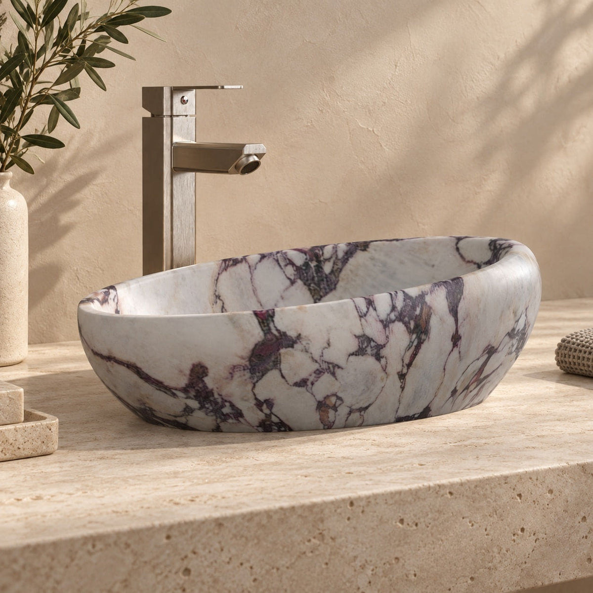 Selema Calacatta marble vessel sink, asymmetric oval bowl, on a countertop from a second angle