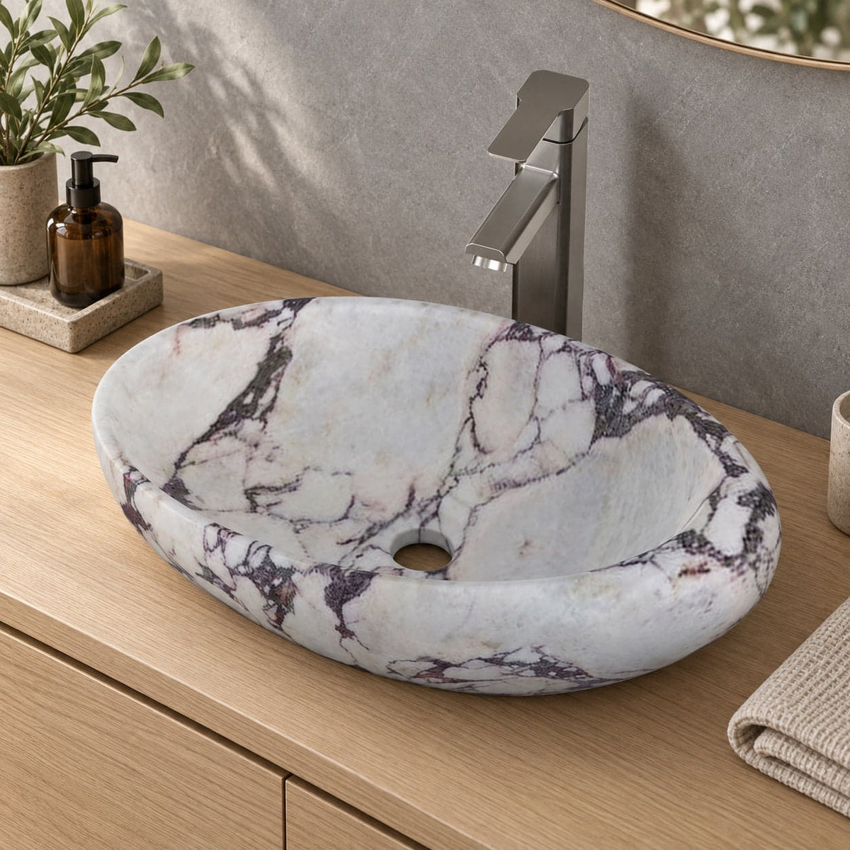 Selema Calacatta marble vessel sink, asymmetric oval bowl, in an overhead or alternate countertop setting
